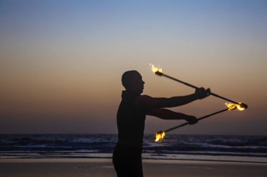 Goa, Hindistan, 9 Şubat 2019: Ateş hokkabazı Arambol plajında ateş çubuklarıyla gösteri yapıyor