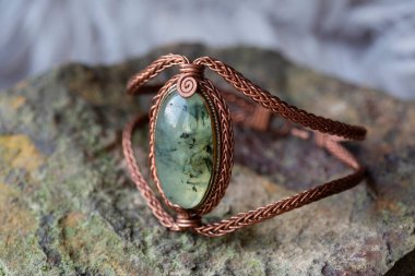 Kayalık zeminde doğal mineral taşı olan bakır tel zarif bilezik.