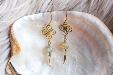 Doğal beyaz kabuklu mineral taşından boncukları olan küçük zarif dişi küpeler.