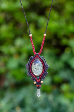 Doğal yeşil bokeh arka planında Macrame mineral taş kolye