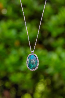 Doğal yeşil bokeh arka planında Macrame mineral taş kolye
