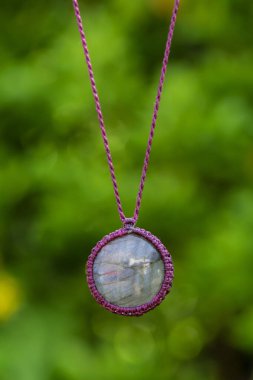 Doğal yeşil bokeh arkaplanlı labradorit taş kolye.