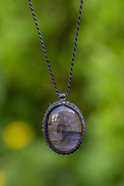 Doğal yeşil bokeh arkaplanlı labradorit taş kolye.