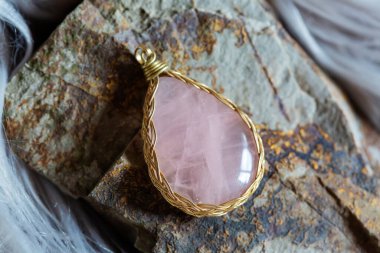 Kayalık zeminde güzel bir mineral gül kuvars taşı kolyesi