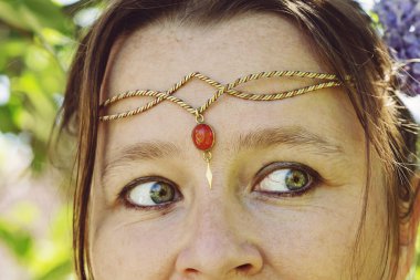 Alnında romantik metal bir taç takan genç kadınların kafalarının yakın çekimi.