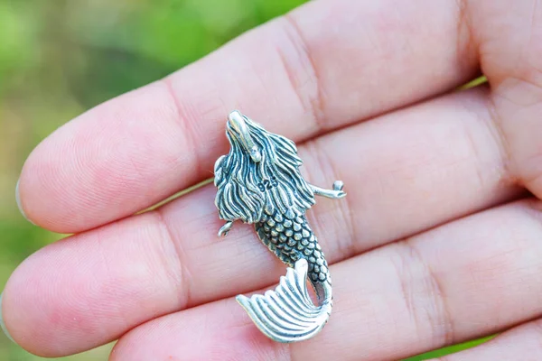 Sterling silver pendant in the shape of mermaid on female hand
