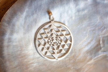 Beyaz kabuk arka plan üzerinde kutsal geometri sri yantra şeklinde Sterling siver kolye
