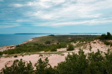 Arka planda Uyuyan Ayı Kumulları 'nın Michigan Gölü ve Güney Manitou Adası' nın manzarası.