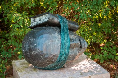 Frederik Meijer Bahçeleri 'ndeki bir kayaya bağlanmış bir kitap heykeli.