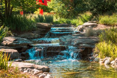 Water cascading down a stream on a summer day in the Frederik Meijer Gardens clipart
