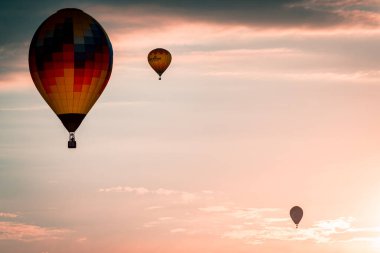 Battle Creek Michigan 'da günbatımında gökyüzünde sıcak hava balonları uçurmak