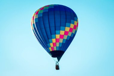 Battle Creek Michigan 'daki bir hava gösterisi sırasında açık mavi gökyüzünde uçan sıcak hava balonu.