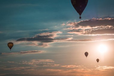 Sıcak hava balonları günbatımında havada süzülüyor Battle Creek Michigan 'daki bir hava gösterisinde.