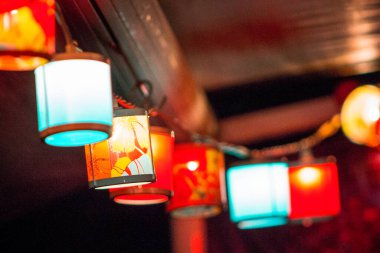 Bir çadırın etrafında asılı renkli ışıklar dizisi