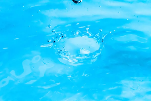 Ondulações de belas gotas de água caindo na água — Fotografia de Stock