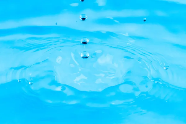 Ondulações de belas gotas de água caindo na água — Fotografia de Stock