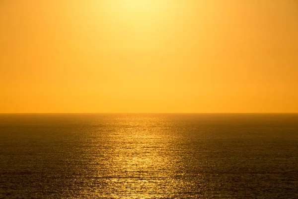 The setting sun shining in the orange sinking in the sea of Japa