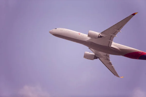 Один самолет летит в голубом небе — стоковое фото