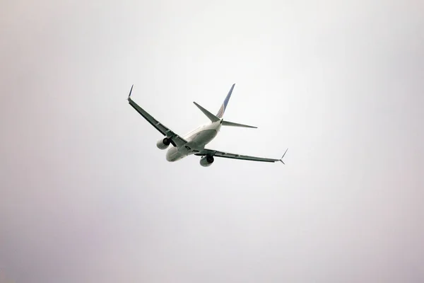 Mavi gökyüzünde uçan bir uçak — Stok fotoğraf