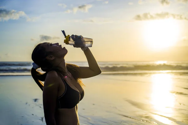 Thirsty beautiful Asian sport runner woman drinking water in fro — Stock Photo, Image