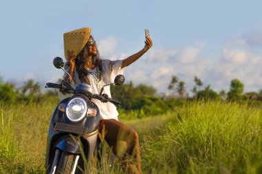 Asya geleneksel şapka sürme motosiklet selfie fotoğraf gülümseyen hareket eden telefon ile mutlu çekici genç çekici siyah afro Amerikalı turist kadın