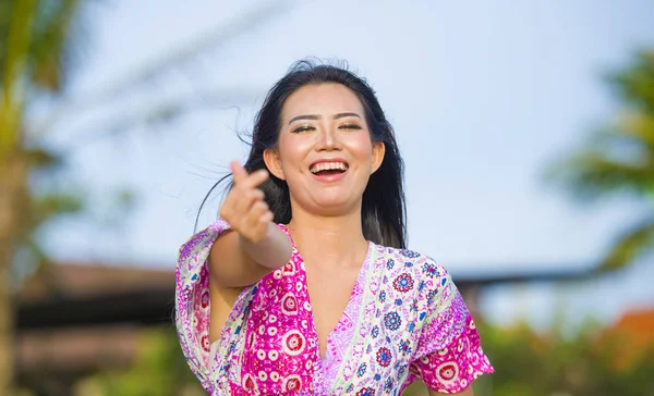 Jonge gelukkig mooie Aziatische Chinese toeristen vrouw doen liefde teken met de vingers en de hand poseren en lachen om tropische badplaats op vakantie — Stockfoto