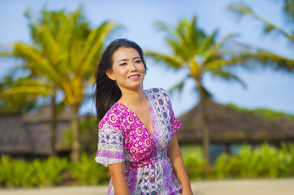 Young happy beautiful Asian Chinese tourist woman smiling relaxed wearing sweet dress walking at beach tropical resort on holidays trip enjoying — Stock Photo, Image