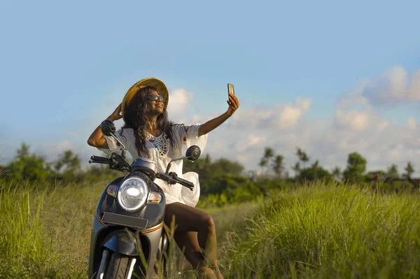 Asya geleneksel şapka sürme motosiklet selfie fotoğraf gülümseyen hareket eden telefon ile mutlu çekici genç çekici siyah afro Amerikalı turist kadın — Stok fotoğraf