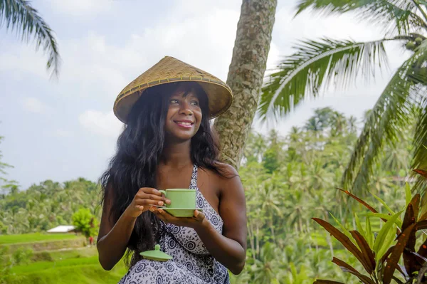 Fiatal szép és boldog fekete afro-amerikai turista nő ivás, kávé vagy tea látogató dzsungel ültetvény, Thaiföld és Vietnam Ázsia termés mezők — Stock Fotó