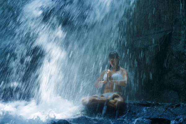 Attraktive Frau sitzt am Felsen in Yoga-Pose für spirituelle Entspannung Gelassenheit und Meditation an atemberaubend schönen Wasserfall und Regenwald in bali — Stockfoto