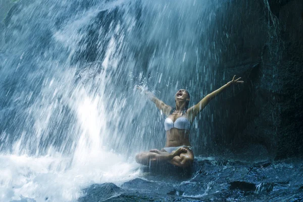 Attraktive Frau sitzt am Felsen in Yoga-Pose für spirituelle Entspannung Gelassenheit und Meditation an atemberaubend schönen Wasserfall und Regenwald in bali — Stockfoto