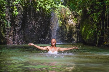 su ve sıçrama tropikal egzotik şelale göl tatil seyahat konsepti de oynamaktan zevk çekici mutlu beyaz turist kadın
