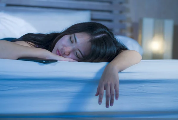 Primer plano retrato de joven dulce y hermosa mujer china asiática de 20 o 30 años durmiendo en la cama junto a su teléfono móvil en internet adicción a las redes sociales — Foto de Stock
