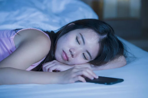 Primer plano retrato de joven dulce y hermosa mujer china asiática de 20 o 30 años durmiendo en la cama junto a su teléfono móvil en internet adicción a las redes sociales — Foto de Stock