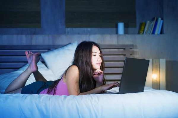 Fiatal, vonzó és szép 20s ázsiai kínai nő ágyon internet segítségével a laptop számítógép figyeli a vonal film éjszaka nyugodt — Stock Fotó