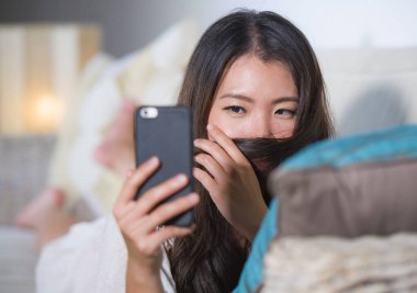 genç güzel ve mutlu Asyalı Çinli kadın evde kanepe yalan Internet üzerinden app içinde hareket eden telefon selfie portre alarak dating kanepe