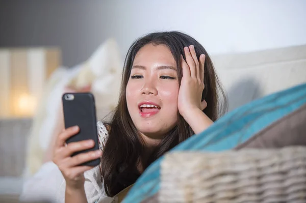 Joven hermosa y feliz asiático chino mujer en su 20s o 30s acostado en sala sofá sofá uso de internet teléfono móvil buscando hermosa — Foto de Stock