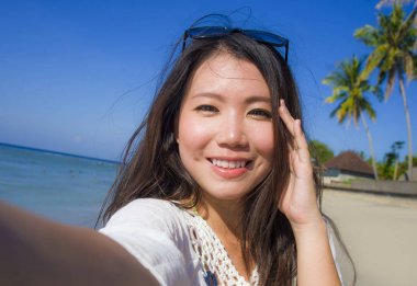 kendi kendine portre muhteşem güzel ve mutlu Asya Kore dili veya Çince kadın 20'li yaşlarda alarak selfie egzotik tropik Beach cep telefonu kamera ile fotoğraf 