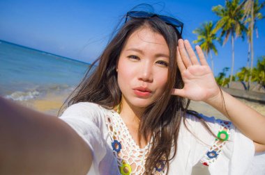kendi kendine portre muhteşem güzel ve mutlu Asya Kore dili veya Çince kadın 20'li yaşlarda alarak selfie egzotik tropik Beach cep telefonu kamera ile fotoğraf 