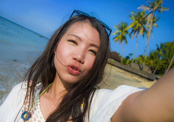 Автопортрет великолепной красивой и счастливой азиатской корейской или китайской женщины 20 лет, делающей селфи фото, отправляющей поцелуй с камерой мобильного телефона — стоковое фото