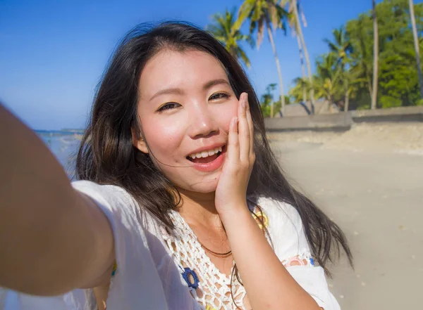 Autorretrato de hermosa hermosa y feliz asiático coreano o chino mujer 20s tomando foto selfie con cámara de teléfono móvil en la playa tropical exótica — Foto de Stock
