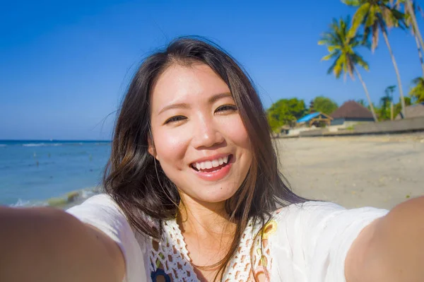 아름 다운 화려한의 자기 초상화와 행복 한 아시아 한국어 또는 중국어 여자 20 대 복용 selfie 이국적인 열 대 해변에서 휴대 전화 카메라로 사진 — 스톡 사진