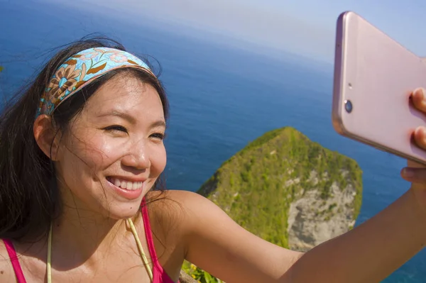 Молодий красивою і щасливою азіатських Корейська туристичних жінка посміхаючись беручи selfie портрет з мобільного телефону в пляж море Скеля краєвид фон — стокове фото