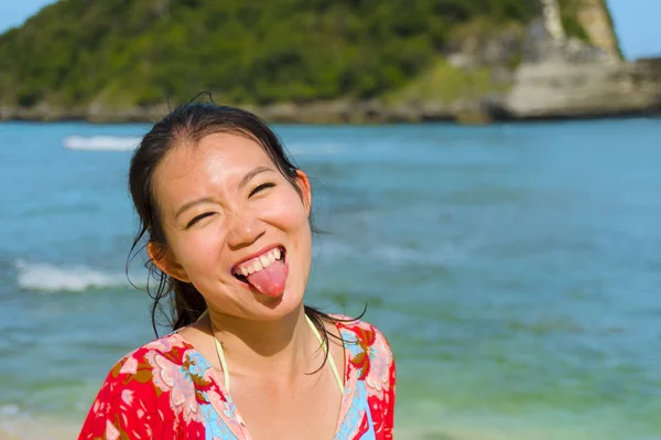 Молодая счастливая и красивая туристка азиатская кореянка в летнем платье наслаждается тропическим раем на пляже, позируя игривая перед морем — стоковое фото