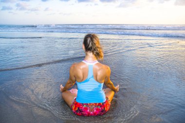 ıslak güneş meditasyon ve gevşeme egzersiz denizde önünde oturan plaj gün batımı yoga pratik egzersiz çekici spor kadın ve genç uygun