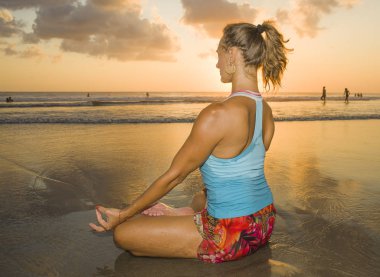 ıslak güneş meditasyon ve gevşeme egzersiz denizde önünde oturan plaj gün batımı yoga pratik egzersiz çekici spor kadın ve genç uygun