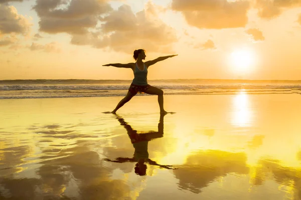 Siluet dari wanita muda yang fit dan sehat menarik berlatih kebugaran dan yoga di pantai indah matahari terbenam dalam meditasi dan konsep relaksasi — Stok Foto