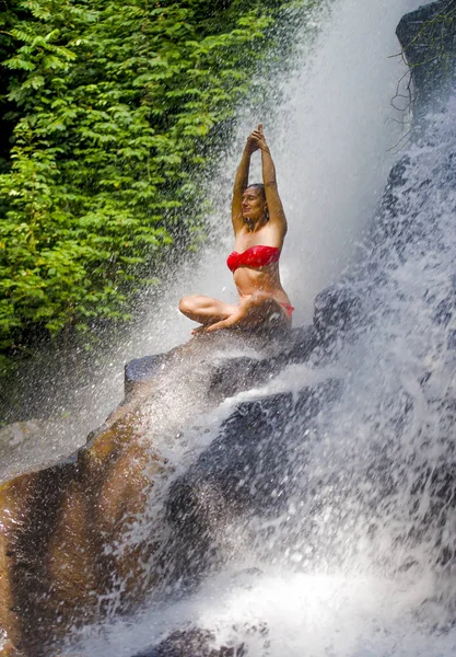 Jovem atraente e feliz mulher dos anos 30 com corpo apto praticando ioga molhado sob o paraíso tropical cachoeira córrego em meditação e relaxamento — Fotografia de Stock