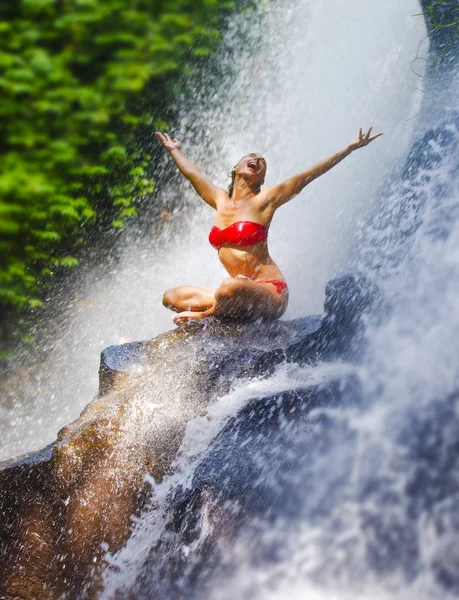 Jovem mulher atraente e feliz com corpo apto praticando ioga molhado sob o paraíso tropical cachoeira córrego gritando animado com braços abertos — Fotografia de Stock