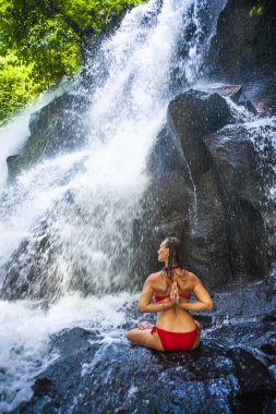 güzel tropik şelale Başlarken ıslak meditasyon mutlu gülümseyerek altında sırtındaki çekici kadının Yoga egzersiz ile poz yapması eller